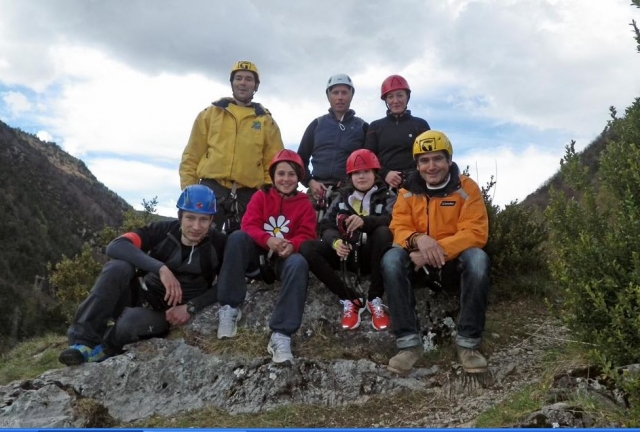  une famille assise sur un rocher entouré d'un cadre naturel 
